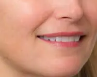 A close up of a woman 's smile with pink lips