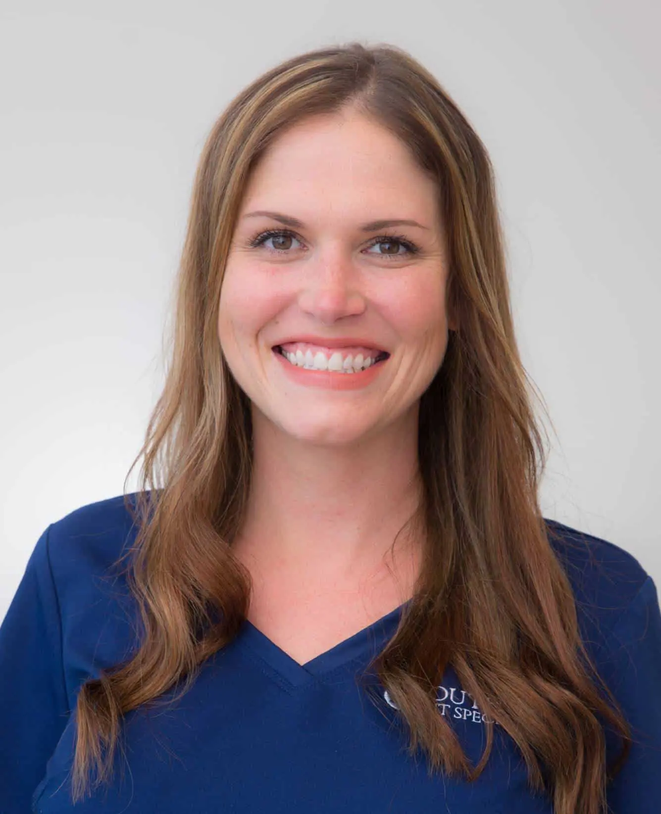 A woman in blue shirt smiling for the camera.