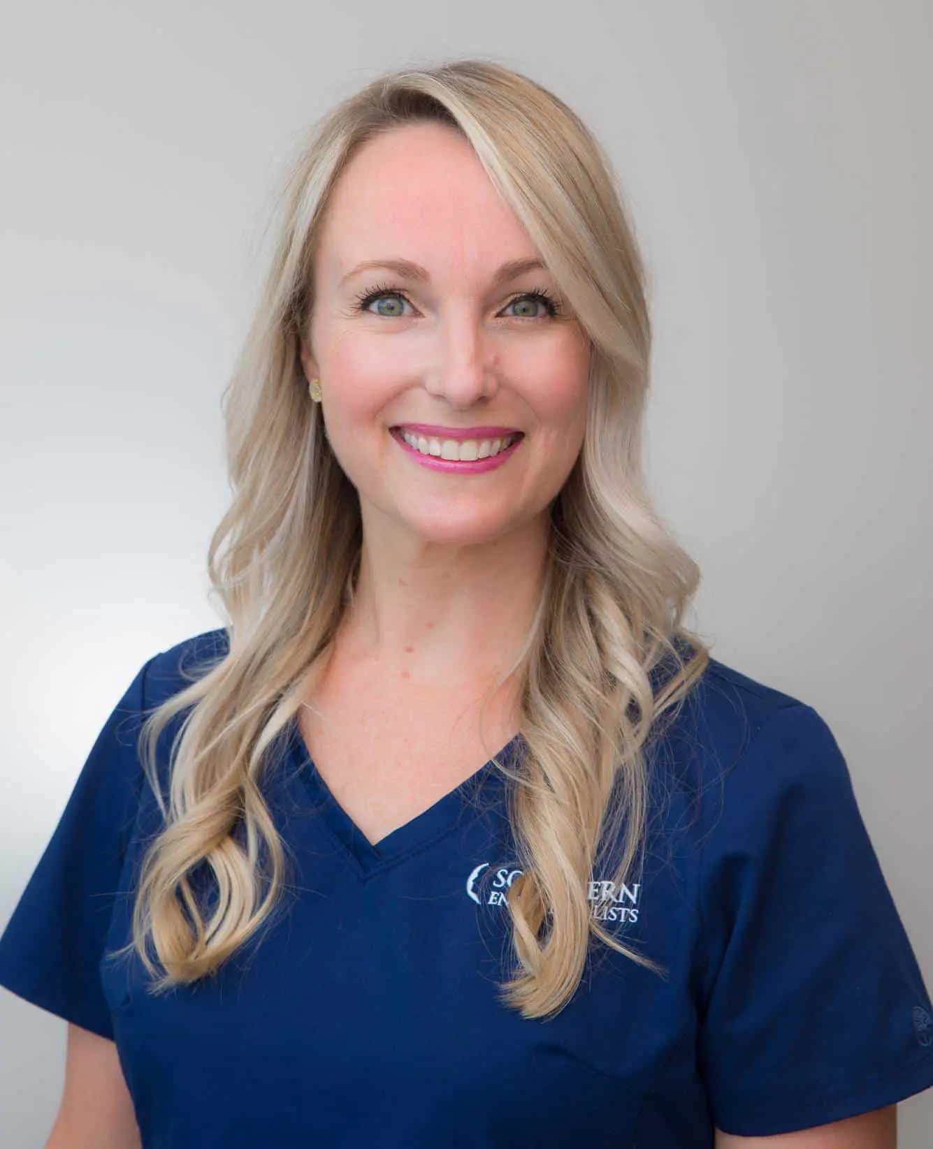 A woman in blue shirt smiling for the camera.