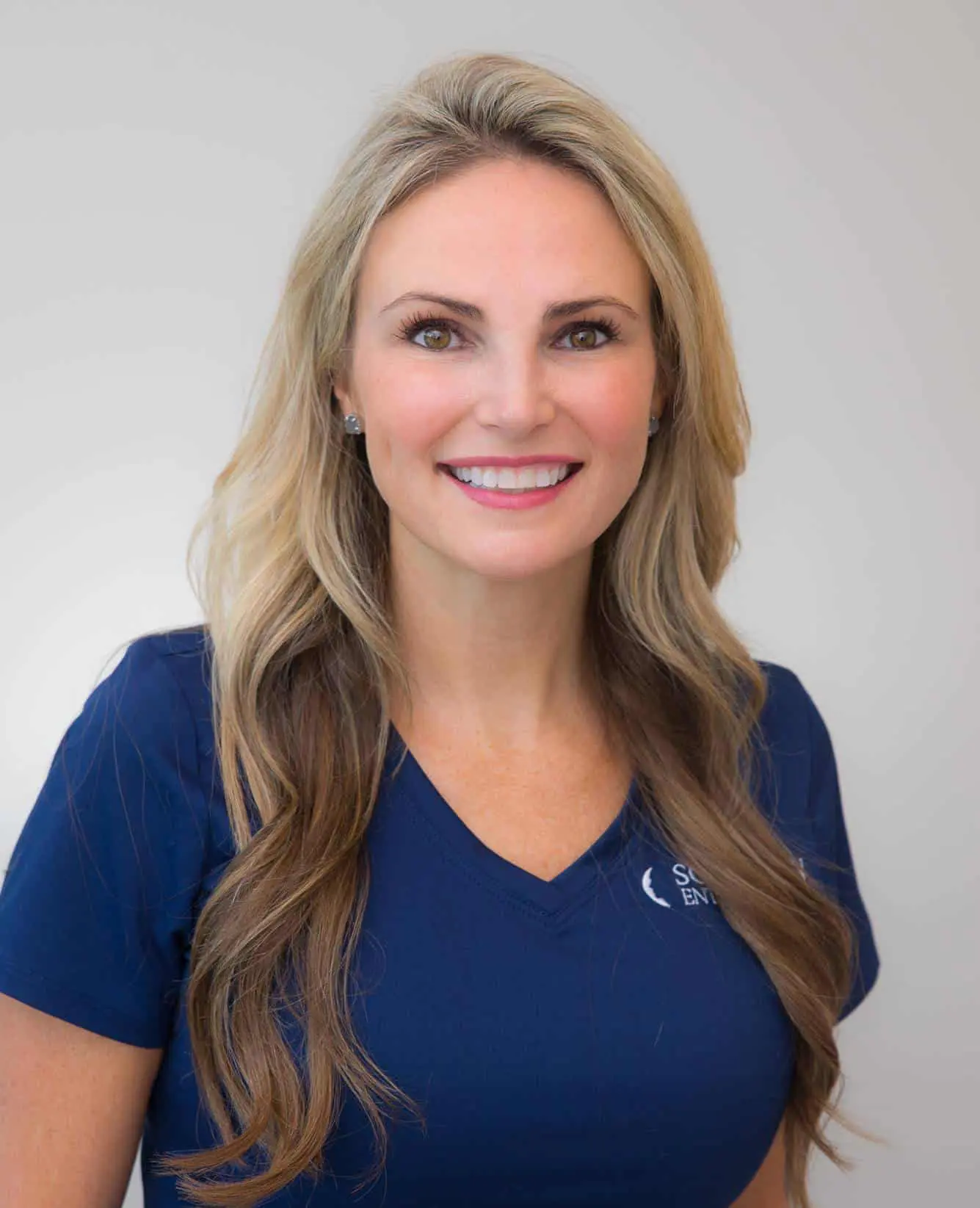 A woman in blue shirt smiling for the camera.