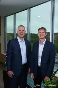 Two men in suits standing next to each other.