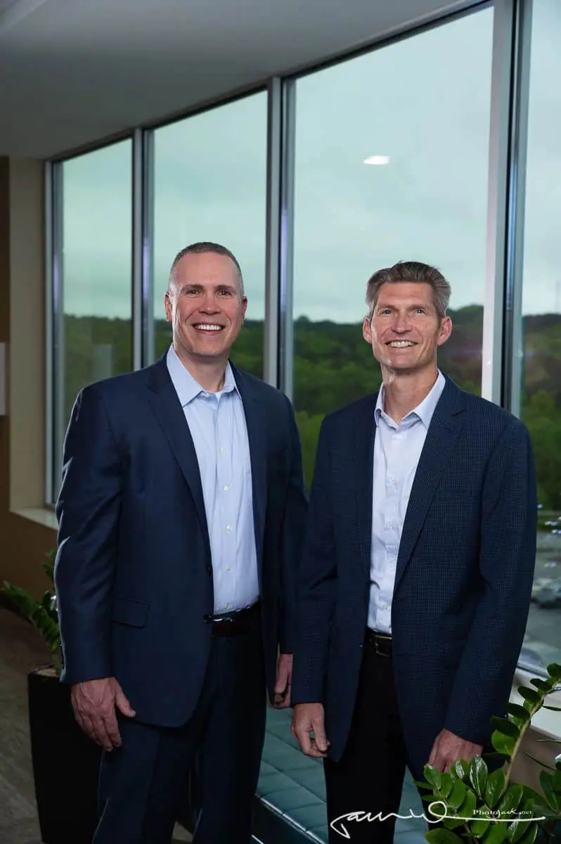 Two men in suits standing next to each other.