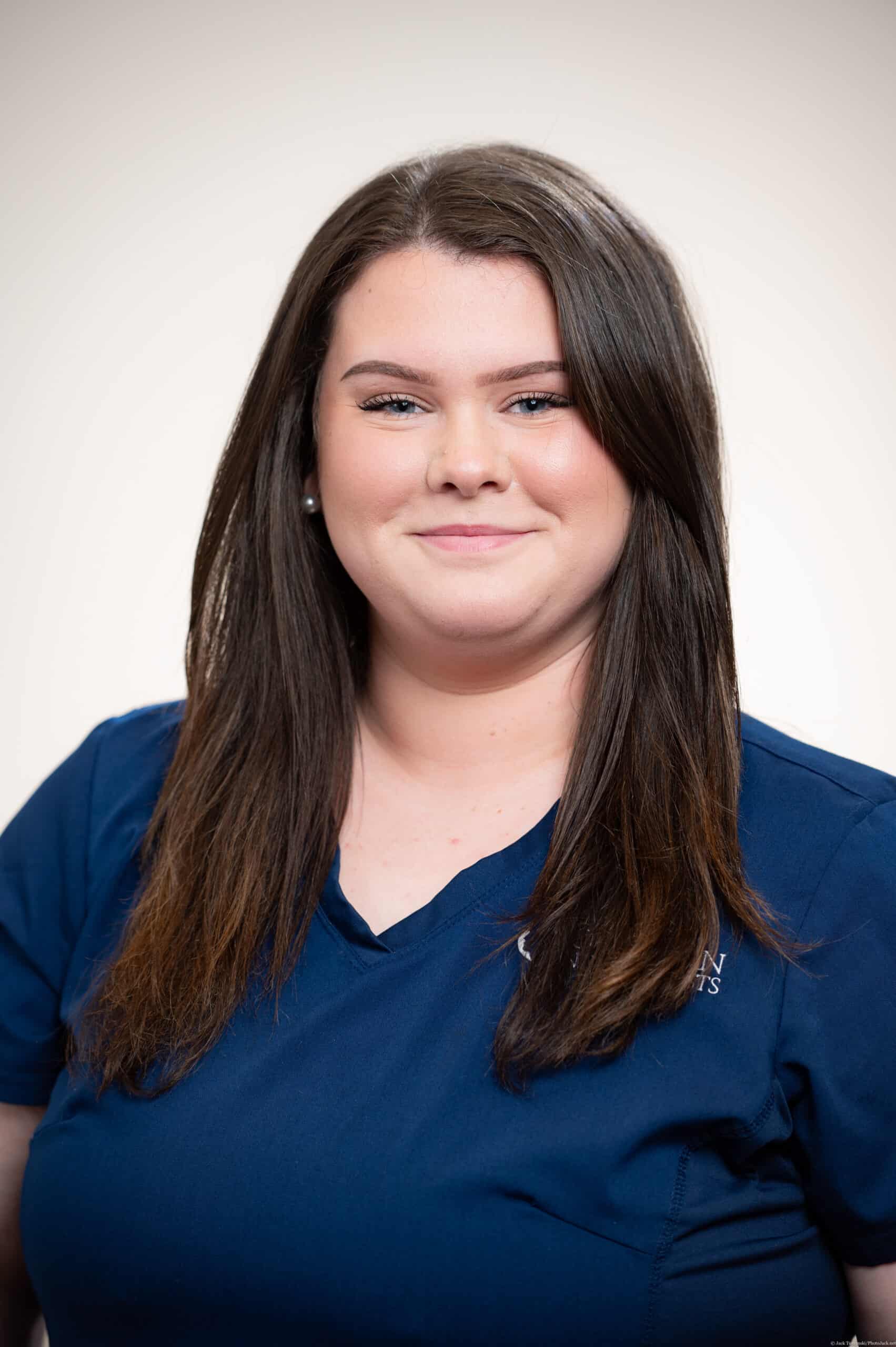 A woman in blue shirt smiling for the camera.